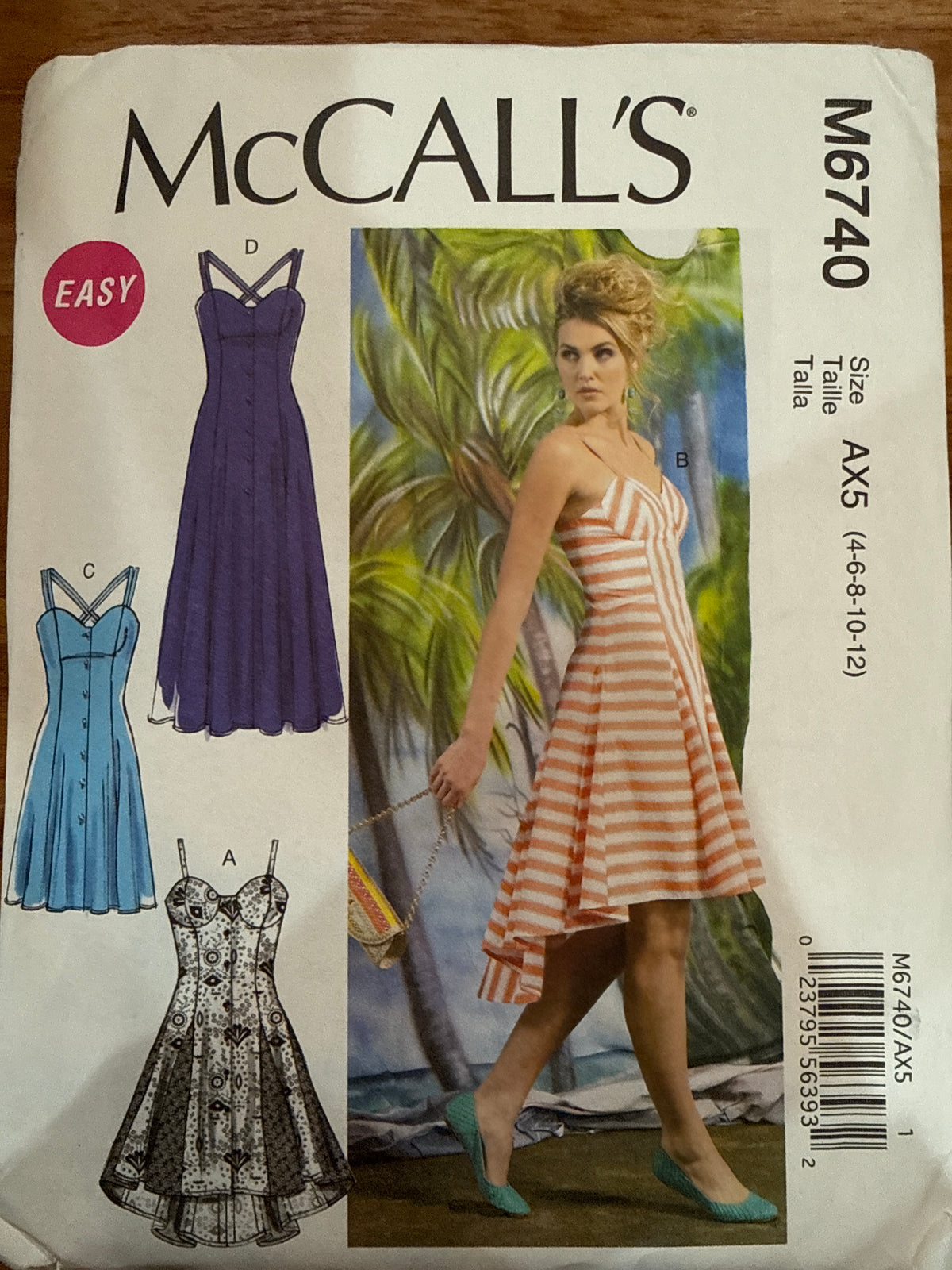 McCall’s M6740 sewing pattern envelope showing fitted, flared dresses with strap and hemline variations.